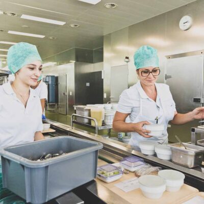 Vorarlberger Krankenhaus-Betriebsgesellschaft M.b.H. Mitarbeiterinnen Am Essen Richten - ©Zeughaus_PatriciaKeckeis